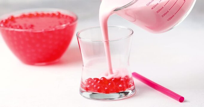 Cold iced fruit bubble tea with juice balls in glass. Trendy drink	