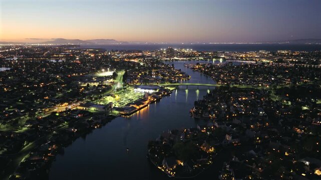 Foster City CA - Aerial View of canal and Shopping Center at Night with Boat Below and Cars on Bridge