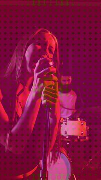 Vertical video: Lead singer gripping mic and leaning, singing while halftone pulsing, music playing
