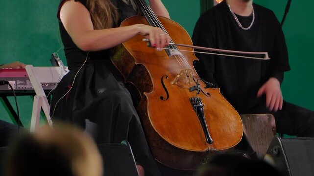 Cellist performing on stage playing cello during live concert