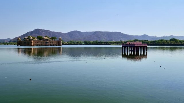 The Jal Mahal and a smaller chhatri structure stand in the calm Man Sagar Lake. Set against the Aravalli hills, this wide view captures the architectural beauty of Jaipur's Water Palace.