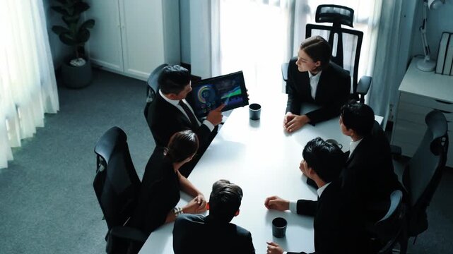 Top view of professional project manager present financial graph while holding tablet. Diverse group working together to analyze stock market investment data graph ay business conference. Directorate.