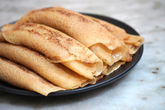 Delicious Homemade Bengali Patisapta Pitha Sweets Placed on a Dark Plate