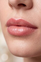 Fototapeta premium Close-up of lips with permanent makeup in soft natural shade. Smooth skin texture, glossy finish, and defined contour create a clean beauty look focused on freshness, symmetry, and subtle elegance.