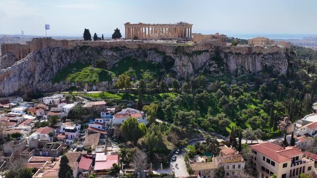 Aerial drone cinematic video above ancient Agora featuring Acropolis hill and the Parthenon, Athens historic centre, Attica, Greece