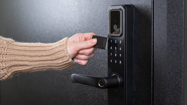 A woman opens a modern smart door lock using a contactless key.