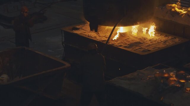 Metal production process in a metallurgical factory. Modern metallurgical factory. Red hot metal in a modern factory. Men workers heat and grind details. Steelworks, Manufactory, modern technology