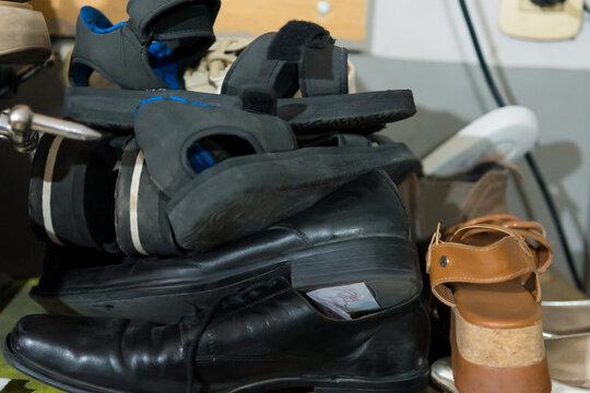 Older Latino upholsterer meticulously repairs a worn backpack in his cluttered workshop