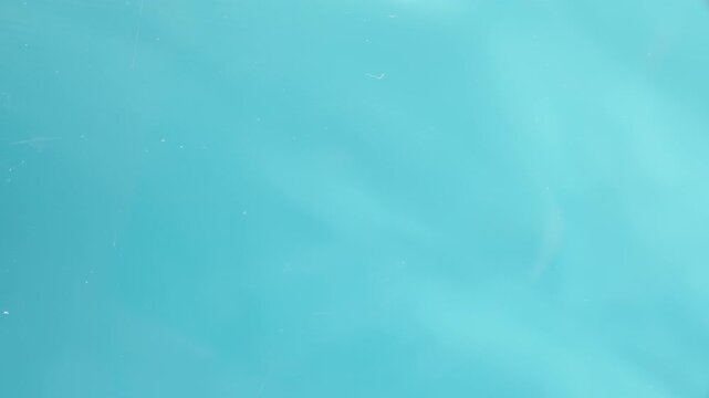 Wooden toothpick on a blue background, a hand picks it up from a glass transparent table. View from below.