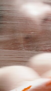 Vertical video. The heart drawn on the glass with red paint, the man spits on it and wipes it with a cloth. Close-up.