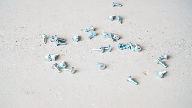 Many Metal Bolts Falling on Concrete Floor with Loud Metallic Rattle Sound
