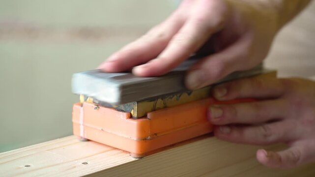 Lapping of a sharpening stone on stone, hoarse hissing sound of grinding
