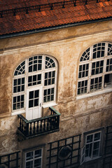 Weathered historic building with arched windows and balcony