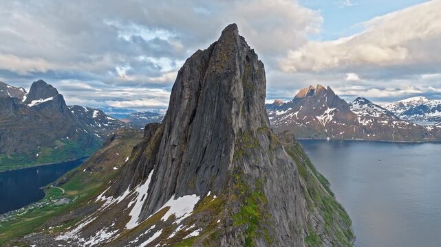 Aerial view of the famous Segla mountain peak above the fjord on Senja Island, Norway. Iconic Arctic summit towers over dramatic coastal landscape.