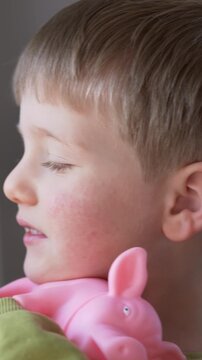 Child with red cheeks and skin rash holding toy illustrating pediatric dermatology concept. Allergy, atopic dermatitis, parvovirus B19 and erythema infectiosum considered with treatment options. 