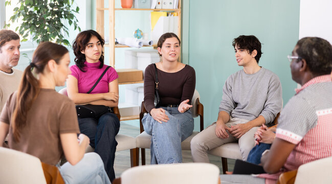 Diverse group of focused people sitting in a circle during an interactive group discussion