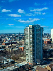 View of city skyline with tall building and cloudy sky from a high point in daytime