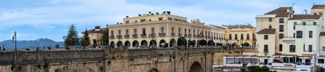 Fototapeta premium Puente Nuevo dramatic bridge spanning a deep limestone gorge creating iconic architectural landmark in Ronda, Spain.