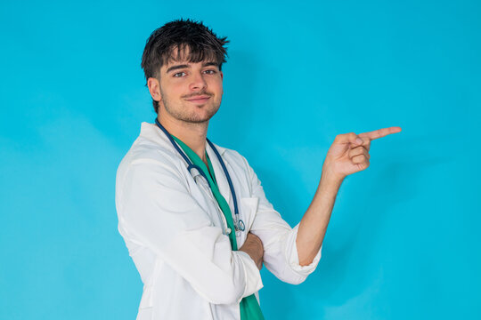 young doctor in uniform with stethoscope isolated on background pointing