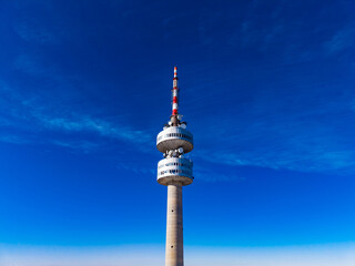 Obraz premium Tall communication tower stands against clear blue sky during daytime in urban area with no visible clouds or buildings nearby