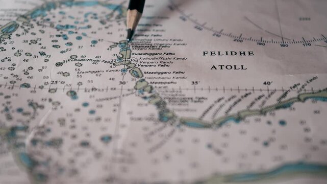 Close-up of a nautical chart with a pencil pointing to a location