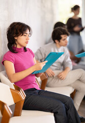 Calm young girl waiting for her appointment while seated in office reception