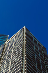 Obraz premium Modern office building stands tall against clear blue sky in a vibrant city during midday light showcasing urban architecture