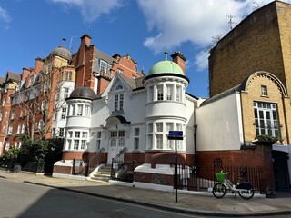 Historic White Turret Building: An older white building in London featuring unique round turret extensions with green roofing. © Curiosity Photos