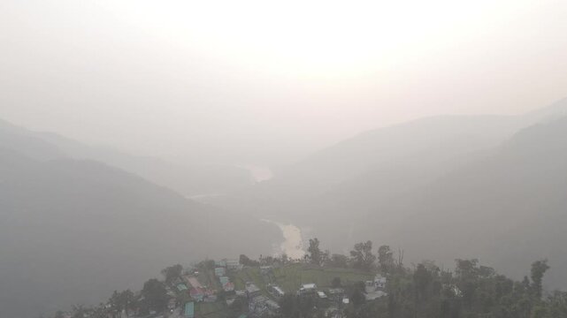 Aerial view of Kuee village in Tehri Garhwal, Uttarakhand, near Rishikesh, with the Ganga River flowing through Tota Ghati, surrounded by lower Himalayan hills and forests of sal, peepal, banyan.