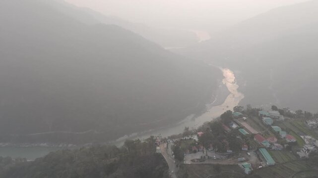 Aerial view of Kuee village in Tehri Garhwal, Uttarakhand, near Rishikesh, with the Ganga River flowing through Tota Ghati, surrounded by lower Himalayan hills and forests of sal, peepal, banyan.