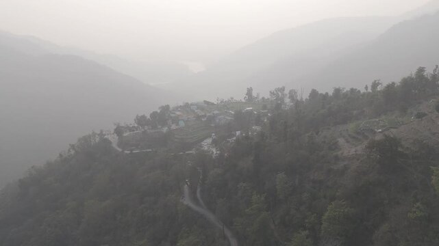 Aerial view of Kuee village in Tehri Garhwal, Uttarakhand, near Rishikesh, with the Ganga River flowing through Tota Ghati, surrounded by lower Himalayan hills and forests of sal, peepal, banyan.