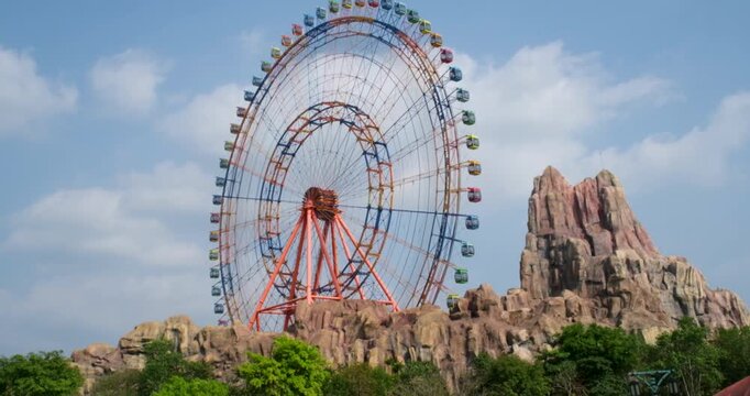 Exterior wide shot of The Wheel of Time Ferris wheel at VinWonders Phu Quoc Adventure World showing the towering structure vibrant park atmosphere and panoramic view on Vietnam theme park.