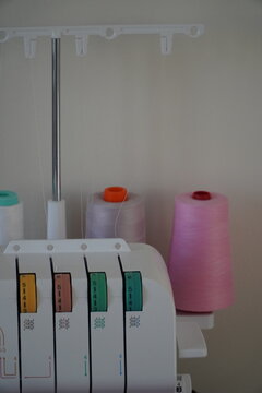 Modern overlock sewing machine, serger, white background with threads