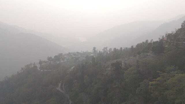 Aerial view of Kuee village in Tehri Garhwal, Uttarakhand, near Rishikesh, with the Ganga River flowing through Tota Ghati, surrounded by lower Himalayan hills and forests of sal, peepal, banyan.