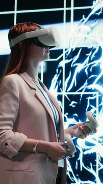 Vertical video Admin wearing VR headset gear reports to AI brain displayed on digital dashboard. Worker completes assignments distributed by artificial intelligence superintelligence using virtual