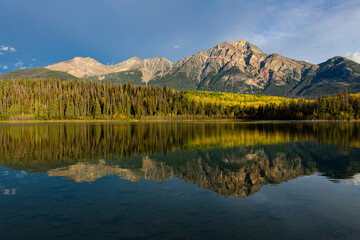 Fototapeta premium Autumn forest reflected in Patricia Lake under clear blue sky 