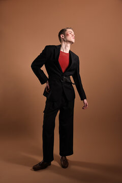 Young man in stylish clothes on brown background