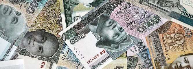 Cambodian riel money bills pile on table. Cambodia banknotes of KHR currency close up. Concept of business, economy and banking in Cambodia © mehaniq41