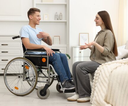Man in wheelchair with woman at home