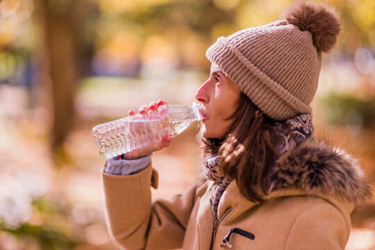 Person staying hydrated in park autumn
