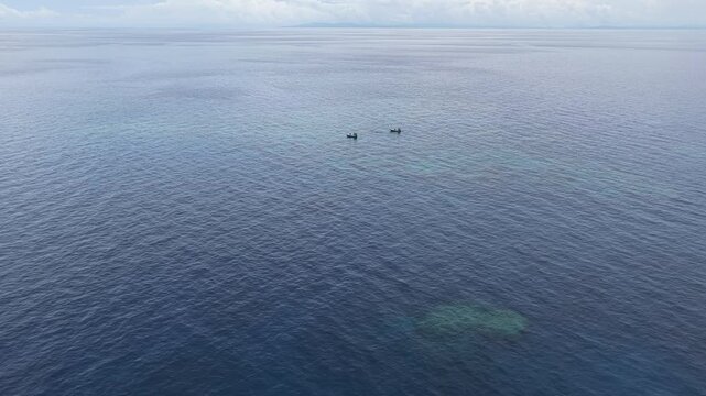 Seen from a bird's eye view, an impressive platform reef, named "E6," sits in the midst of the Bligh Channel east of Viti Levu, Fiji. The reef is home to extensive coral growth and fish diversity.