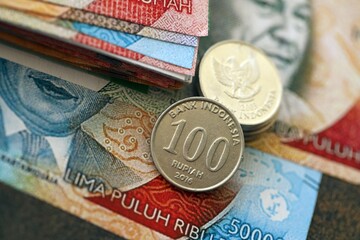 Indonesian rupiah money bills and sen coins pile on table. Indonesia coins on banknotes of IDR currency close up. Concept of business, taxes and banking in Indonesia © mehaniq41