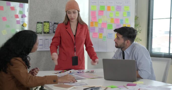 Diverse group of startup team engaging in brainstorming session, using sticky notes on glass wall to organize ideas, plan next steps. Creativity and collaborative spirit of modern entrepreneurial team