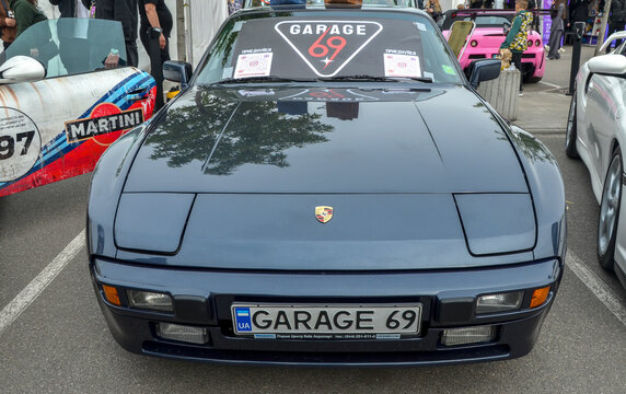 Dark blue Porsche 944 with pop-up headlights, celebrated for its near perfect weight distribution, which provided exceptionally balanced and agile handling