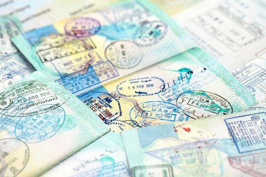 Many open passport pages with lots of visas and entrance stamps from various countries passport control. Concept of travel and tourism worldwide