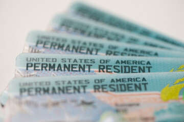 United States Permanent Resident cards stacked together. Concept of immigration, residency status, identity documentation, and legal authorization to live and work in the USA. © Kenishirotie