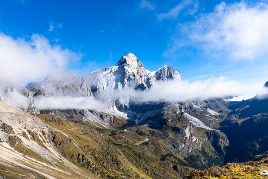Scenic alpine landscapes along the Yading Big Kora and the famous Rock Trail in Daocheng Yading, Sichuan, China, featuring sacred snow mountains, high-altitude valleys, drifting clouds, glacial lakes,
