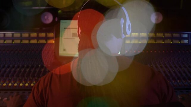 Vertical video: Monitor playback starting engineer tweaking faders mixing audio while bokeh moving