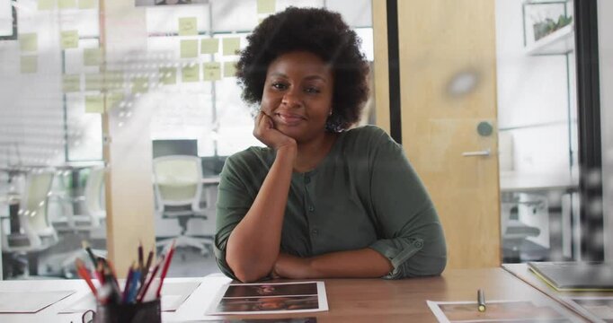 Female designer sitting behind glass map overlay drifting revealing face while reviewing proofs