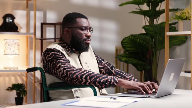 African man navigating the professional world with accessibility and inclusion, working on a laptop